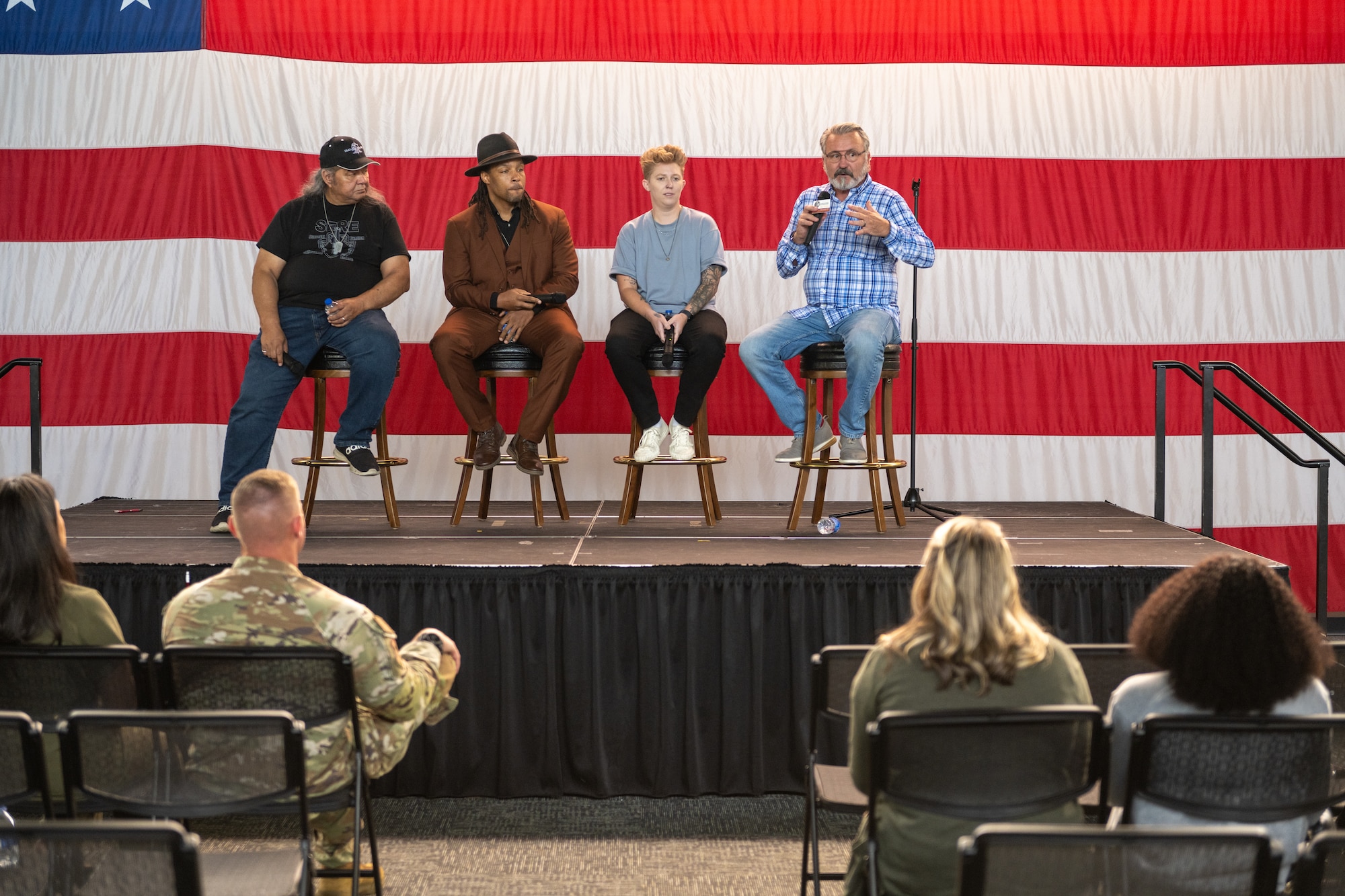 People sitting on a stage in front of an audience.