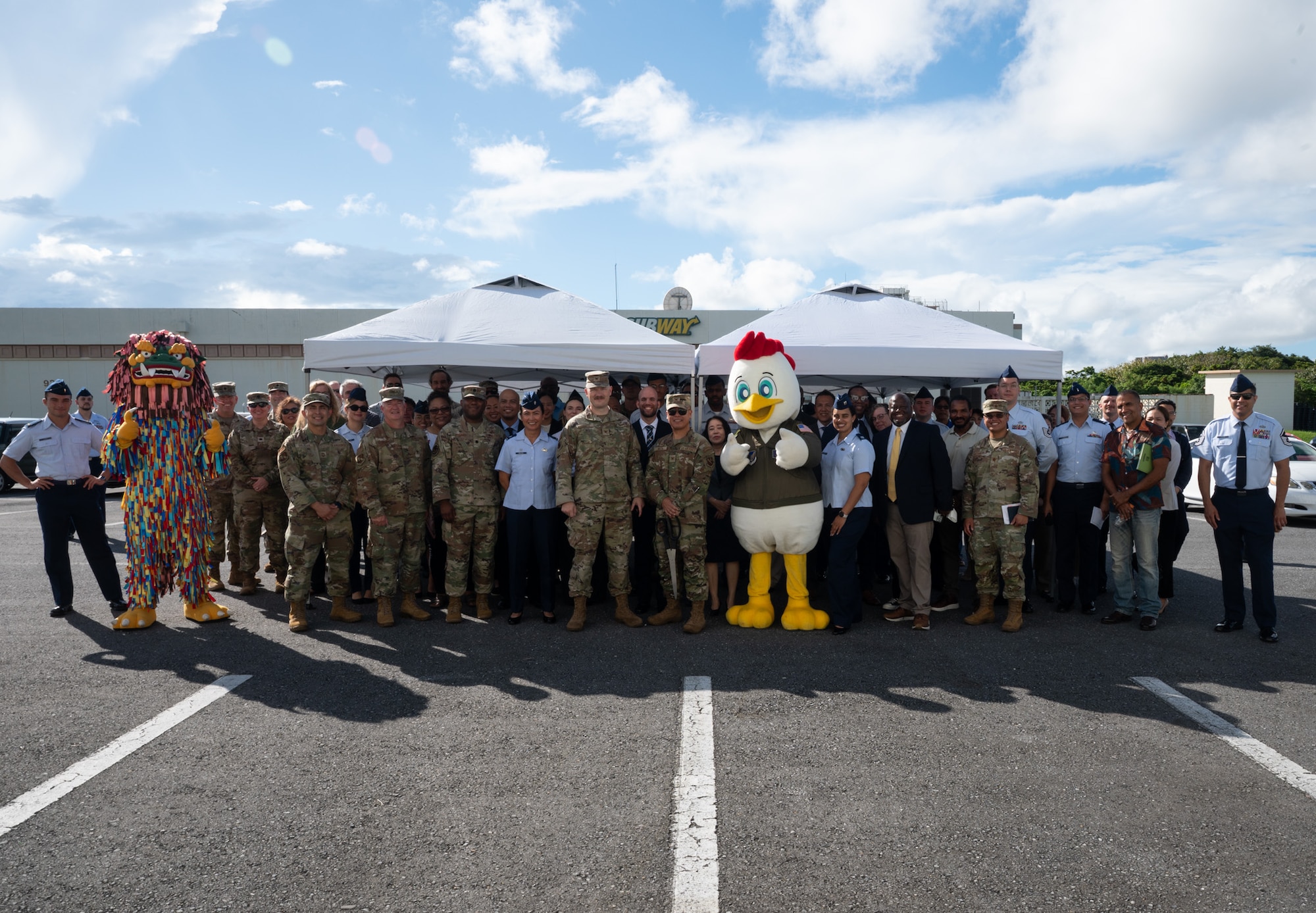 Service members and mascots pose for a group photo.