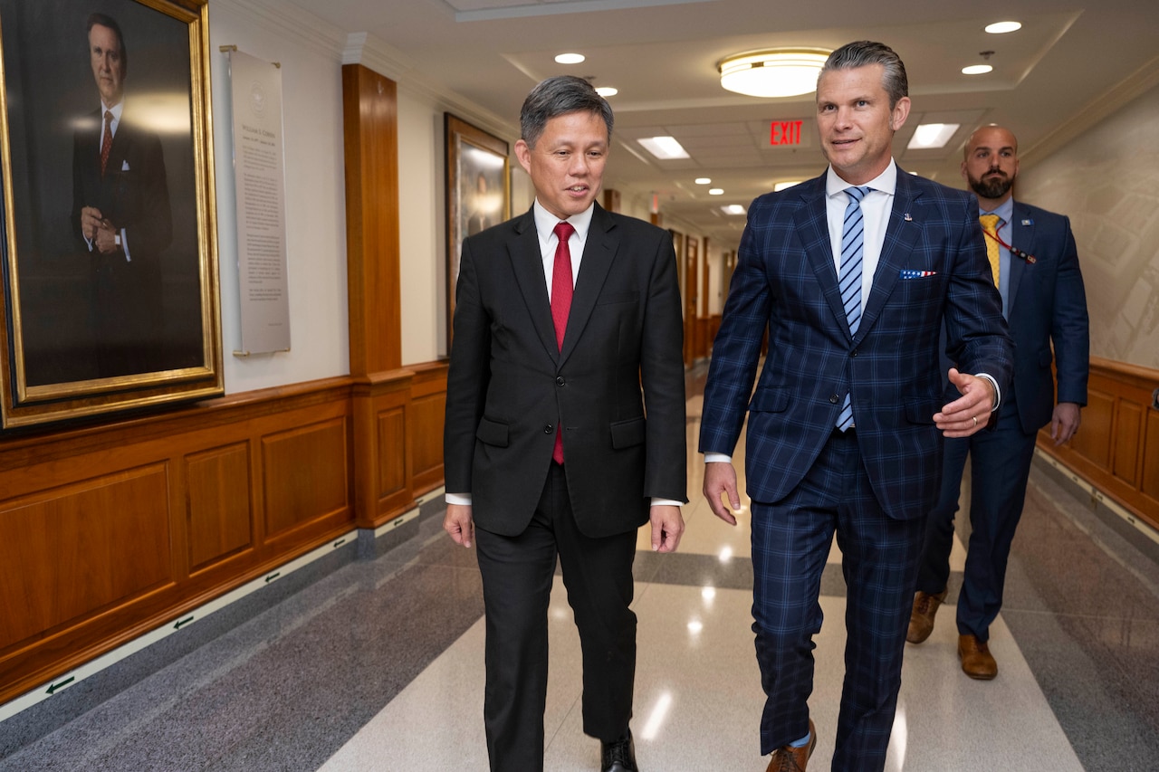 Secretary of War Pete Hegseth walks with his Singapore counterpart at the Pentagon.