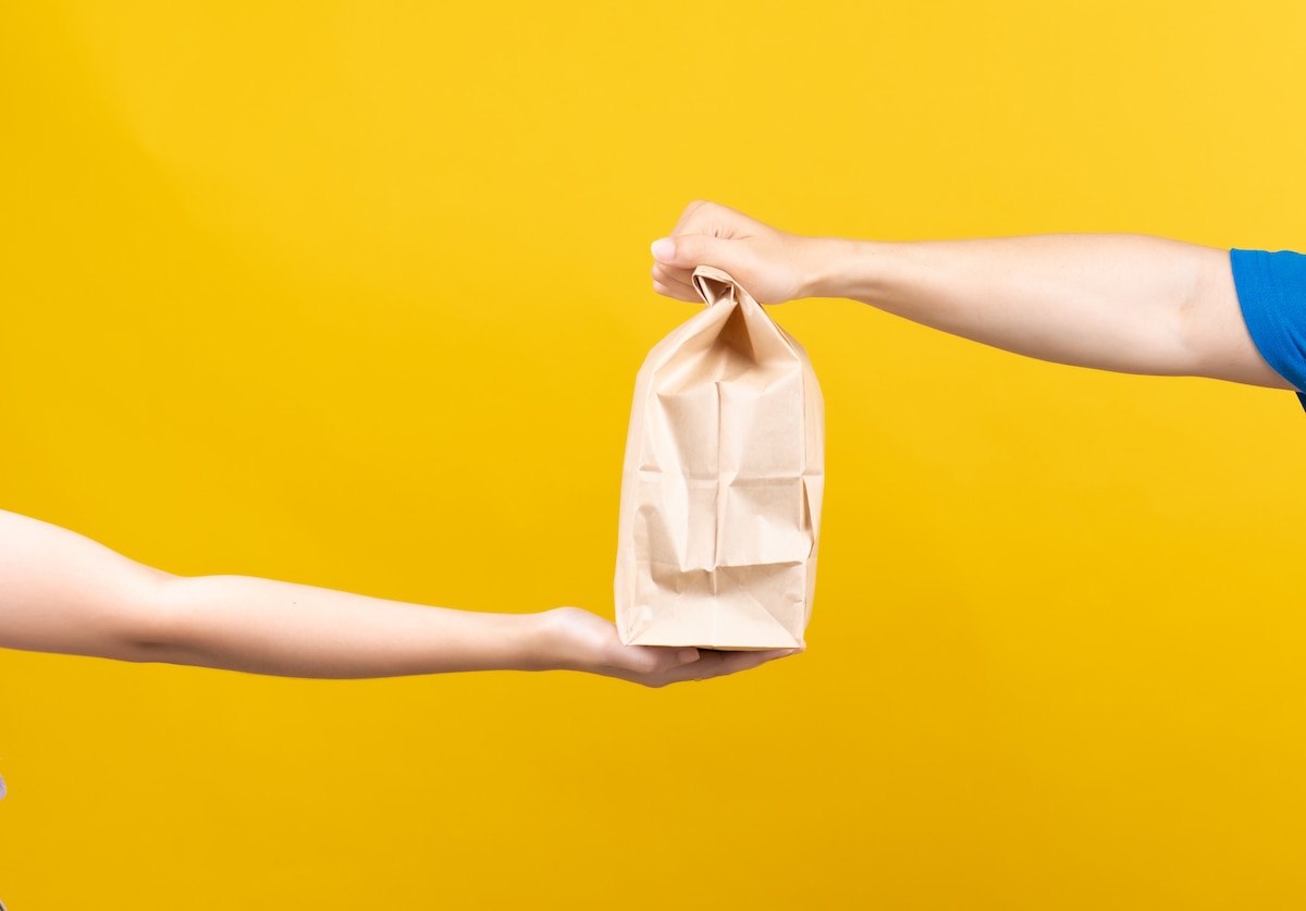 Image of hand-to-hand delivery of food.