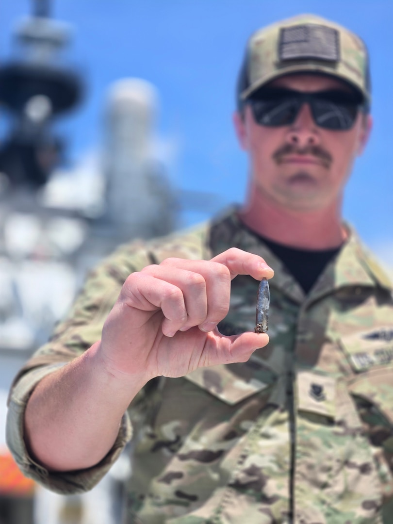A precision marksman assigned to the Coast Guard Helicopter Interdiction Tactical Squadron (HITRON) displays a recovered ammunition round used to disable the engine of a suspected drug smuggling vessel while underway aboard Coast Guard Cutter Midgett (WMSL 757) in the Eastern Pacific Ocean, Aug. 31, 2025. On Aug. 25, HITRON used airborne use of force to stop the non-compliant vessel, marking the unit’s 1,000th drug interdiction since the unit’s inception in 1999, which resulted in Midgett crew members seizing approximately 3,606 pounds of suspected cocaine worth an estimated $46 million and apprehending six suspected narco-traffickers. (U.S. Coast Guard photo)