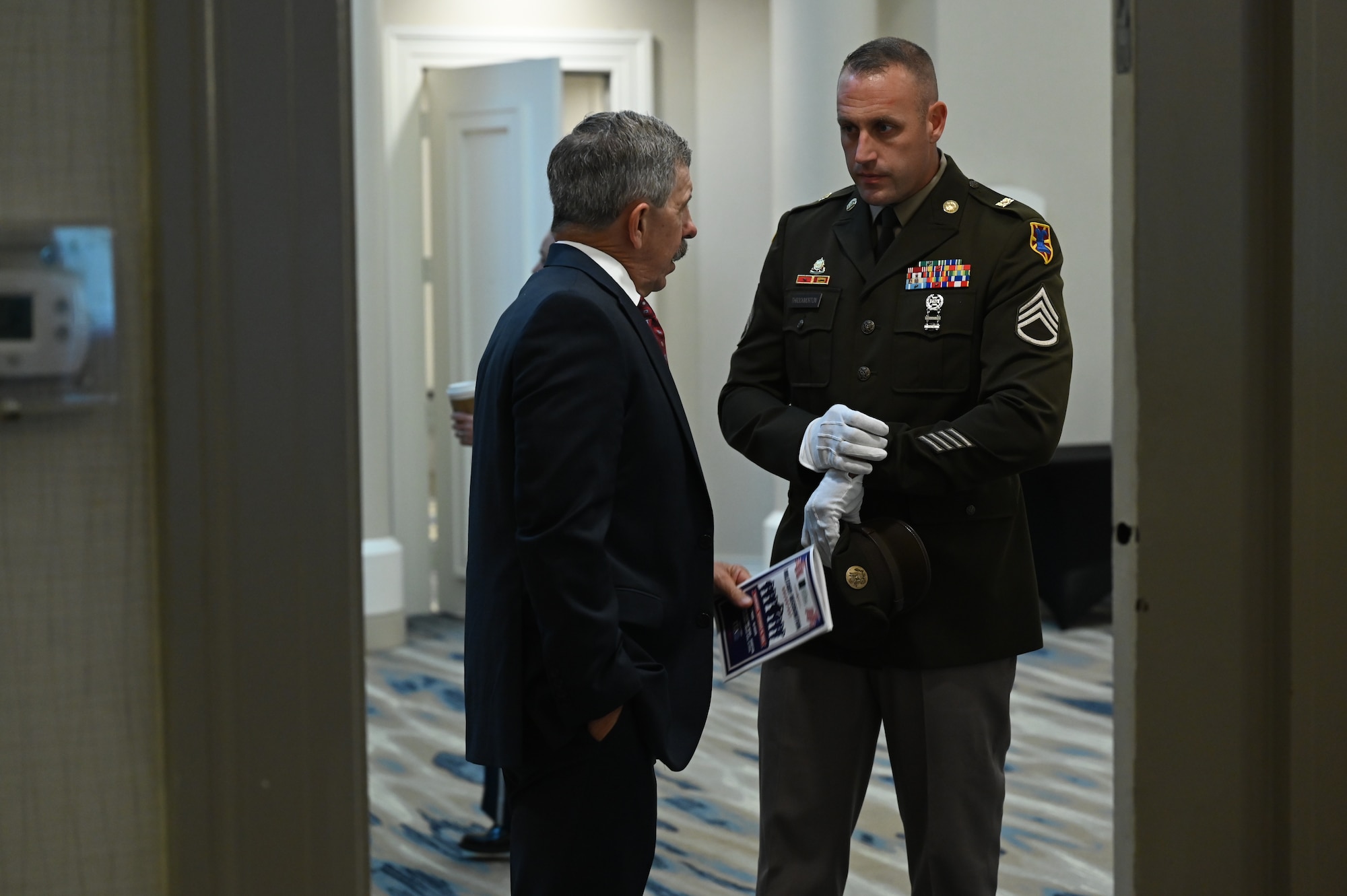 Two people talk in a hallway.