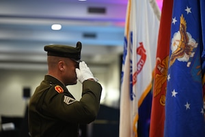 Soldier salutes flags.
