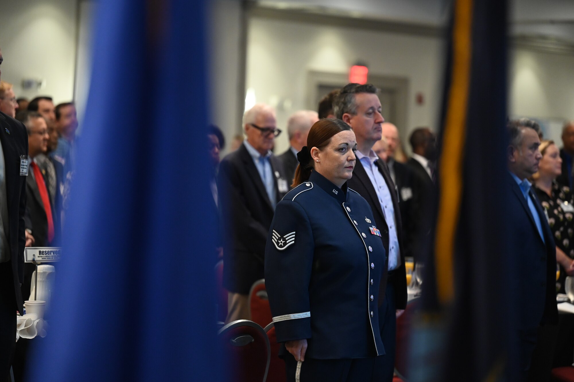 Attendees stand for a moment of silence.