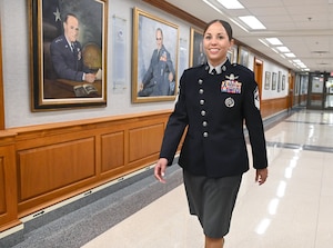 A military member walks down a hallway.