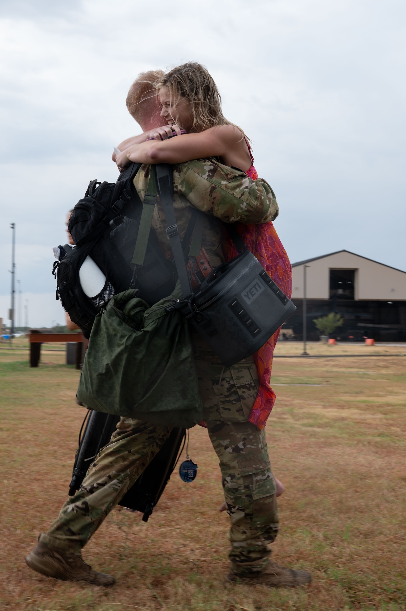 A U.S. Air Force Airman assigned to the 317th Airlift Wing embraces his family after returning home from deployment at Dyess Air Force Base, Texas, Sept. 5, 2025. Operating on a staggered schedule, Airmen from the 317th AW have been deployed non-stop for the last 12 months to the Middle East, while concurrently executing border support missions and Indo-Pacific high-end exercises. (U.S. Air Force photo by Airman William Neal)