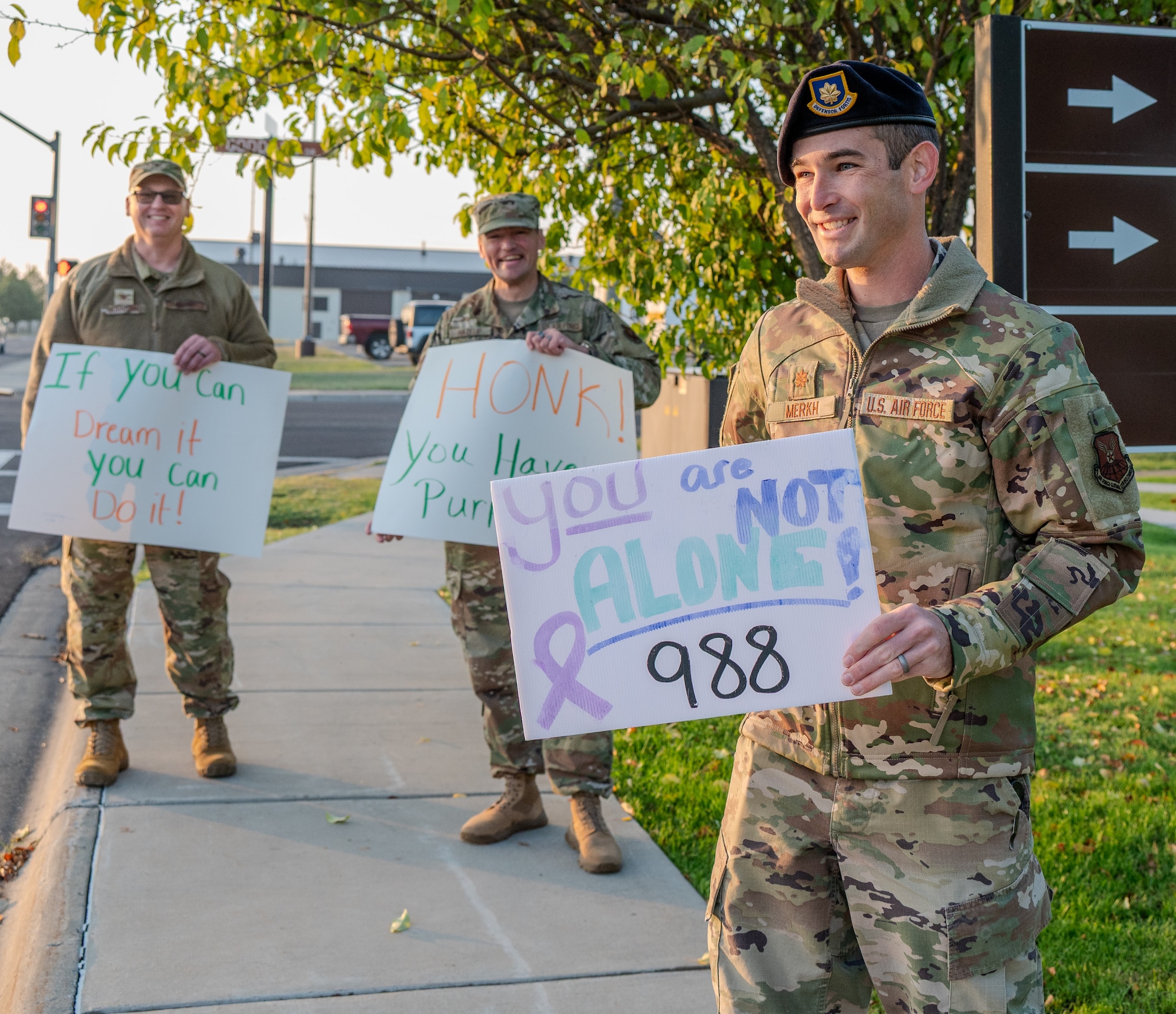 Smiling airmen hold positive signs