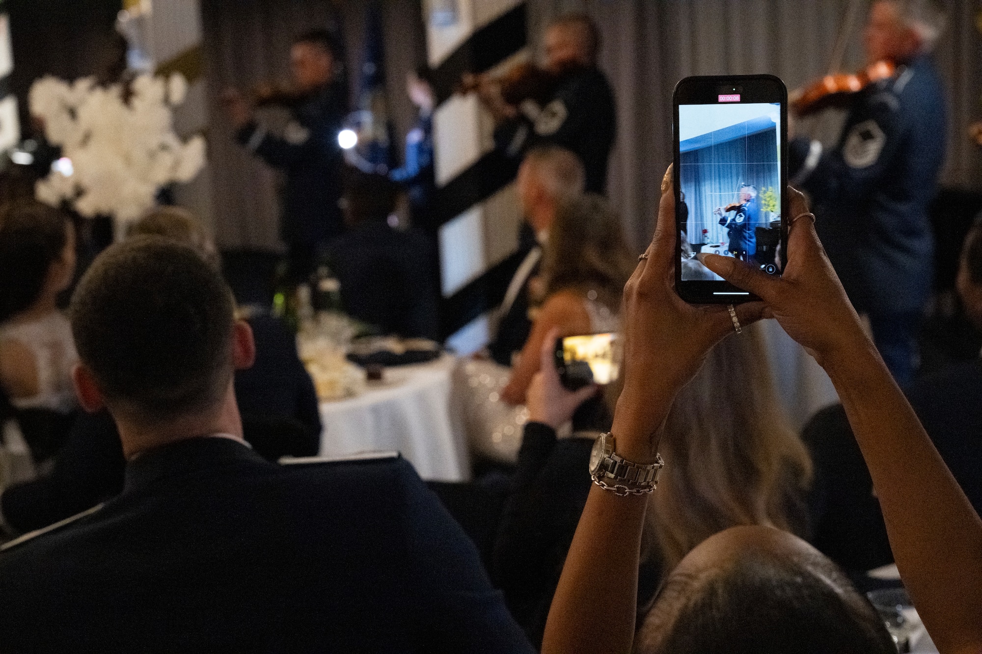 A Joint Base Anacostia-Bolling U.S. Air Force 78th Birthday Ball attendee records a performance of The U.S. Air Force Band’s Strolling Strings on JBAB, Washington, D.C., Sept. 5, 2025. The Strolling Strings provided a modern touch on classical entertainment, inspiring listeners and honoring Air Force heritage. (U.S. Air Force photo by Hayden Hallman)