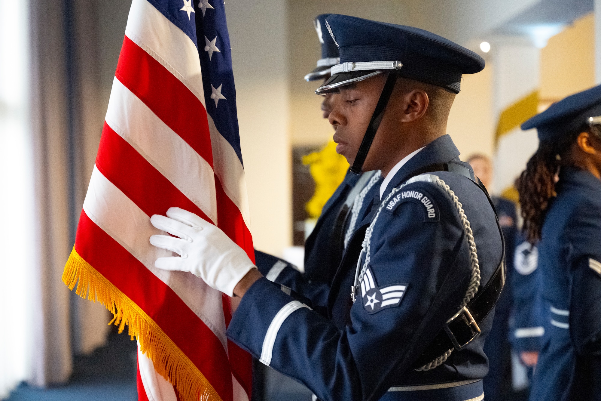 U.S. Air Force Senior Airman Khalil Reed, ceremonial guardsman with the U.S. Air Force Honor Guard, dresses the American flag during the Joint Base Anacostia-Bolling U.S. Air Force 78th Birthday Ball, Washington, D.C., Sept. 5, 2025. The Honor Guard delivered premier ceremonial honors in support of the event. (U.S. Air Force photo by Hayden Hallman)