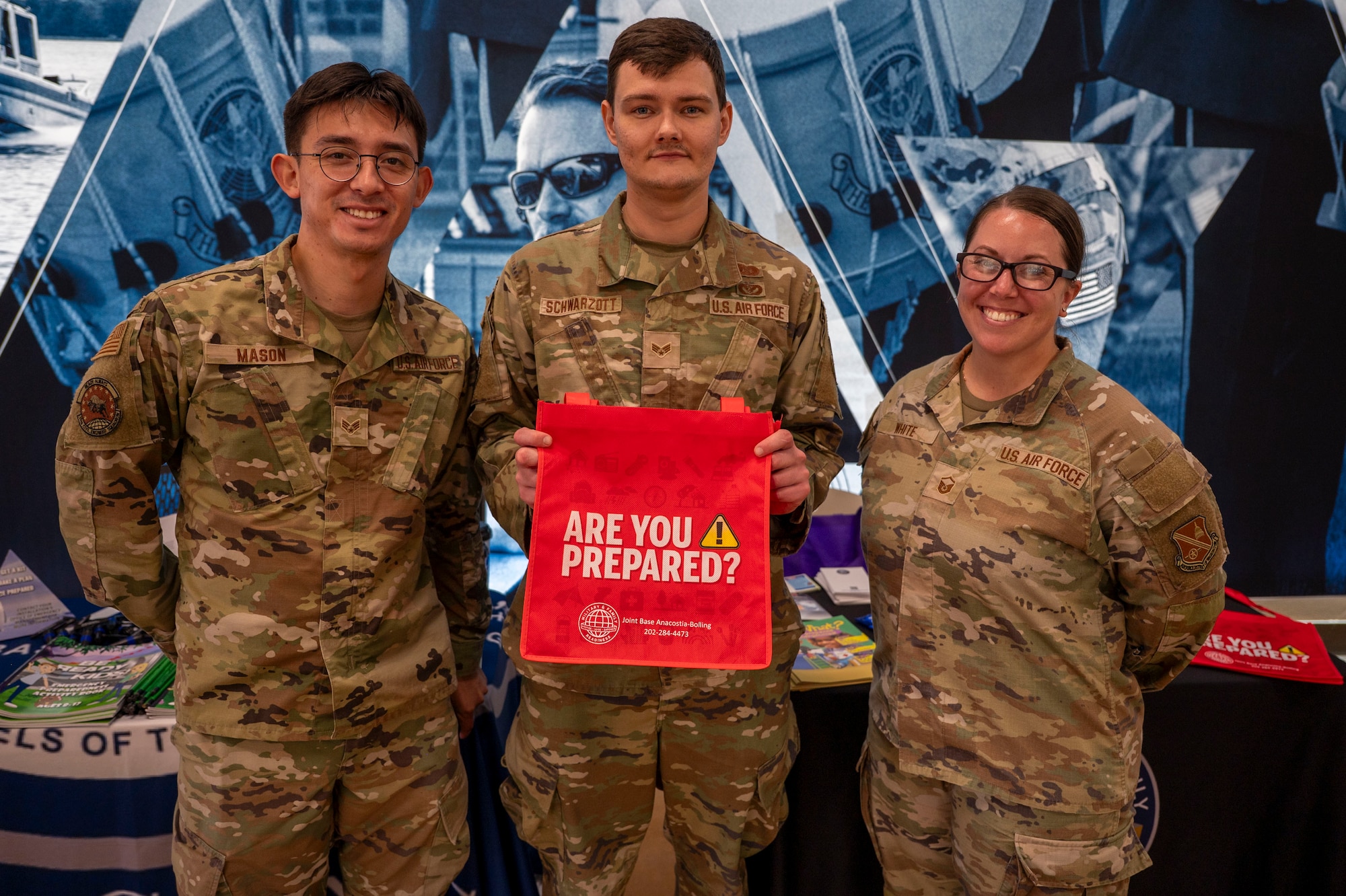 From left, U.S. Air Force Senior Airmen Noah Schwarzott and Cristian Mason, both emergency management journeymen assigned to the 11th Civil Engineer Squadron, and Master Sgt. Candice White, Joint Base Anacostia-Bolling Military Family Readiness Center superintendent, staff a National Preparedness Month booth at JBAB, Washington, D.C., Sept. 9, 2025.