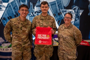 From left, U.S. Air Force Senior Airmen Noah Schwarzott and Cristian Mason, both emergency management journeymen assigned to the 11th Civil Engineer Squadron, and Master Sgt. Candice White, Joint Base Anacostia-Bolling Military Family Readiness Center superintendent, staff a National Preparedness Month booth at JBAB, Washington, D.C., Sept. 9, 2025.
