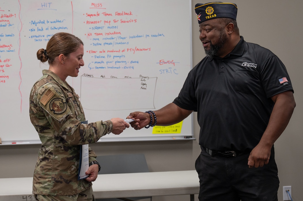 Staff Sgt. Lindsey Neubauer, 433rd Aeromedical Staging Squadron, was presented with a membership to American Legion Post 300 by Ventura "Ace" Tounsel, during the 433rd Medical Group’s commander’s call, Aug. 2, 2025.