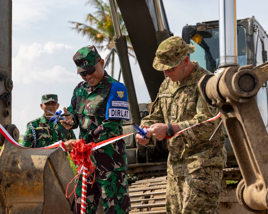 Indonesian Armed Forces Lt. Gen. Naudi Nurdika, commander of the Indonesian Army Education and Training Command, left, and Canadian Brig. Gen. Robert McBride, deputy commanding general, operations, 11th Airborne Division, right, cut ribbons opening a newly constructed road during exercise Super Garuda Shield 25 in Baturaja, Indonesia, Sept. 2, 2025.
