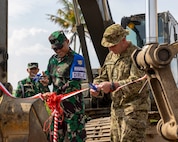 Indonesian Armed Forces Lt. Gen. Naudi Nurdika, commander of the Indonesian Army Education and Training Command, left, and Canadian Brig. Gen. Robert McBride, deputy commanding general, operations, 11th Airborne Division, right, cut ribbons opening a newly constructed road during exercise Super Garuda Shield 25 in Baturaja, Indonesia, Sept. 2, 2025.