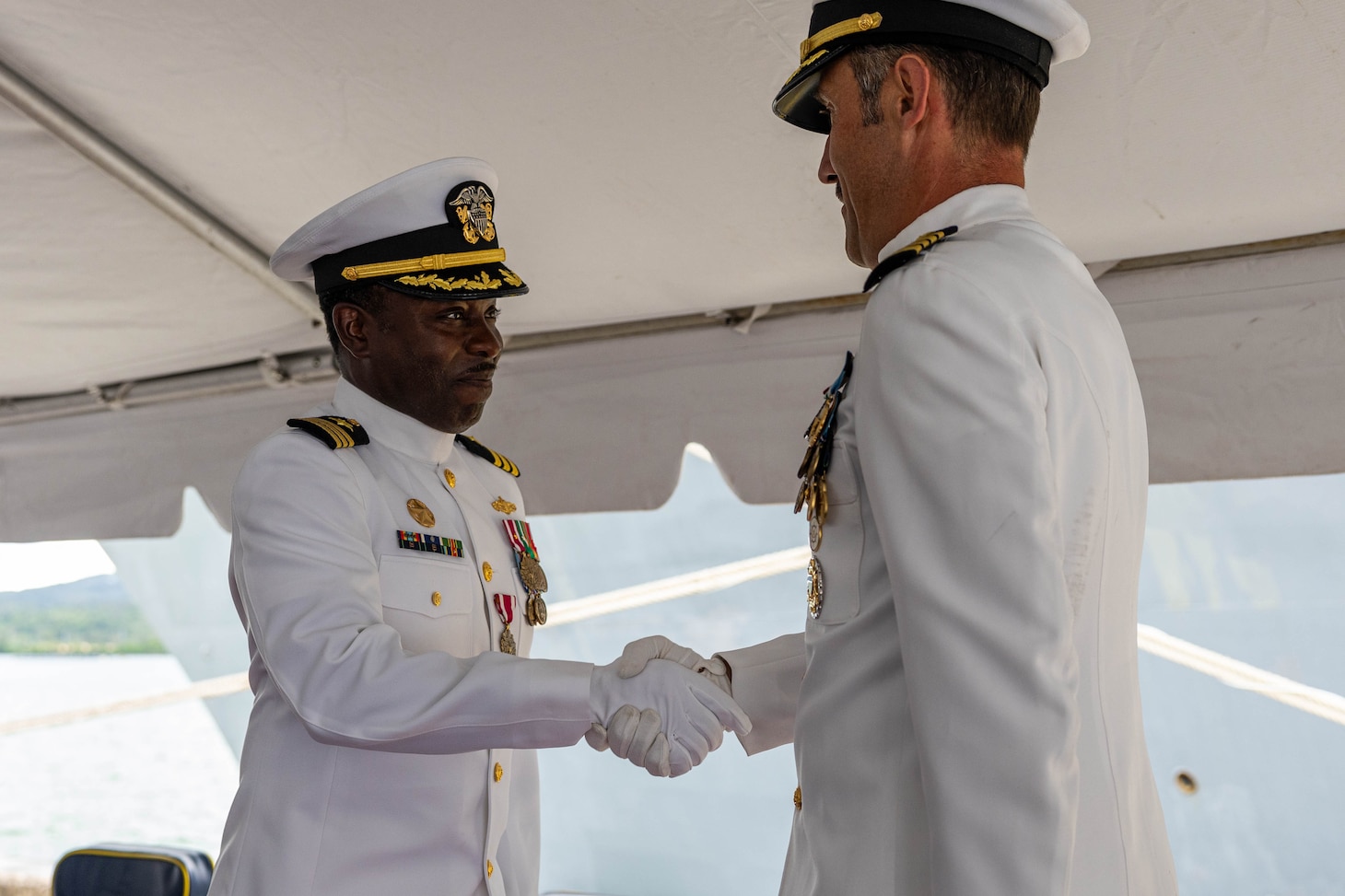 APRA HARBOR, Guam (Aug. 24, 2025) Cmdr. Ronald Jenkins, outgoing commanding officer of the Arleigh Burke-class guided-missile destroyer USS Higgins (DDG 76), left, shakes hands with Capt. Dave Huljack, commodore of Destroyer Squadron (DESRON) 15, during the Higgins change of command ceremony onboard Naval Base Guam in Apra Harbor, Guam, Aug. 24. Higgins is forward-deployed and assigned to DESRON 15, the Navy’s largest DESRON and the U.S. 7th Fleet’s principal surface force. (U.S. Navy photo by Mass Communication Specialist 2nd Class Trevor Hale)
