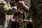 U.S. Army Maj. Ryan Hubbs congratulates an Ecuadorian marine on the completion of air assault training during a ceremony at the end of an air assault training exchange in Latacunga, Ecuador, Aug. 21, 2025. The skull is the insignia of the 9th Special Forces Brigade of Ecuador, and adorns uniforms, equipment, and static displays across the unit. At the conclusion of an exchange, it is also customary for partners to trade patches as a gesture of camaraderie. (U.S. Army National Guard photo by Sgt. Caleb Sooter)