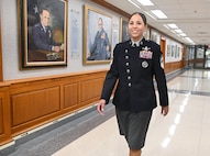 A military member walks down a hallway.