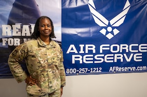 Master Sgt. Denise Alston, recruiting flight chief for the 315th Airlift Wing, stands beside a Reserve marketing display outside her office at Joint Base Charleston, South Carolina, Aug. 2, 2025. Recruiters play a critical role in preparing future Airmen for military service.