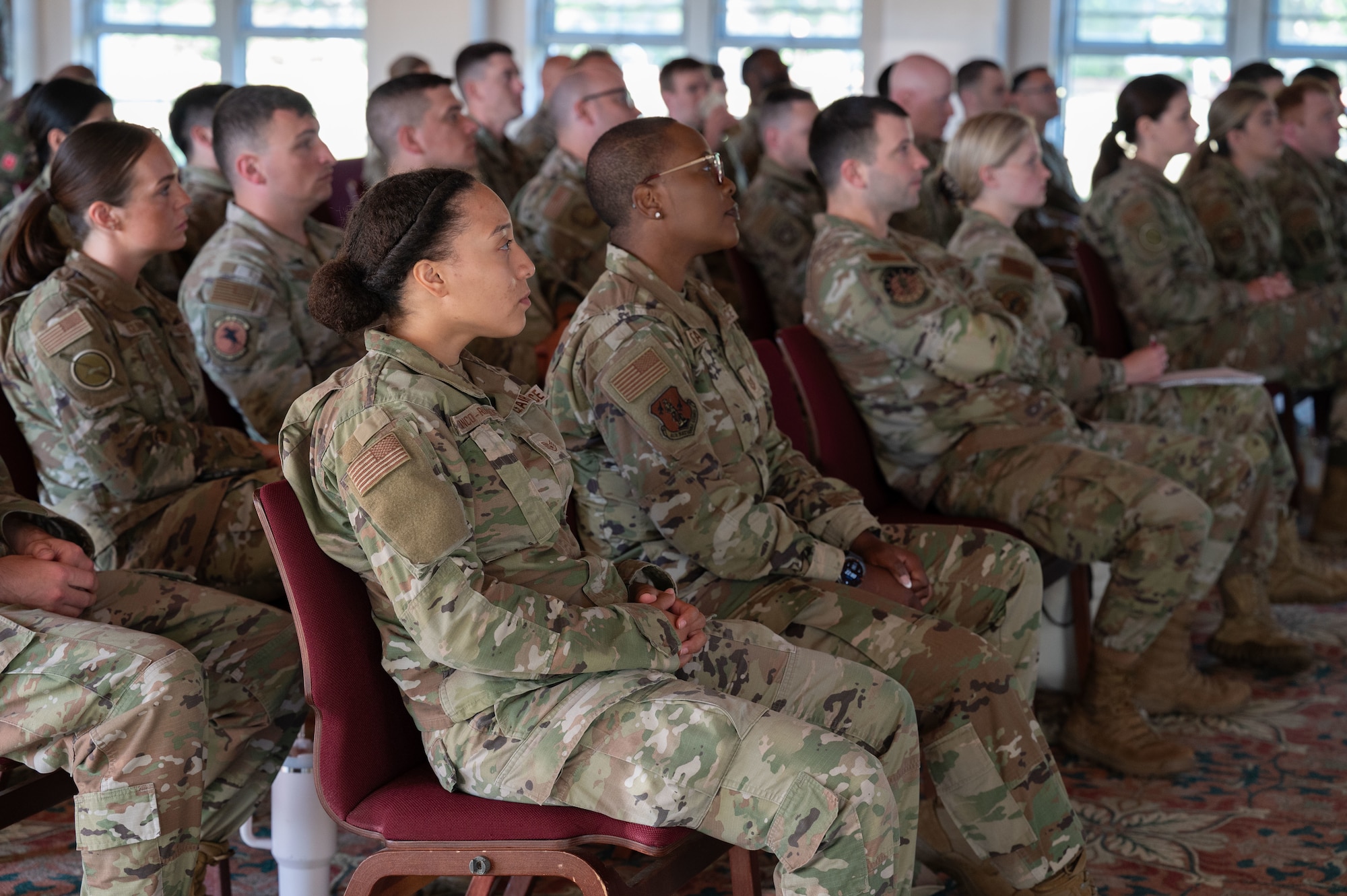 Airmen sit in a classroom.