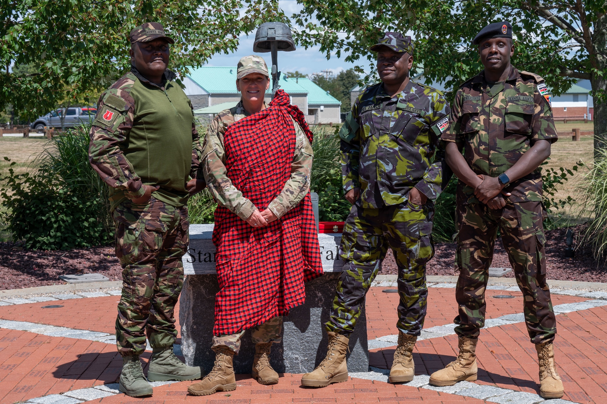Airman wears a shuka and stands with members of Kenya Defence Force.