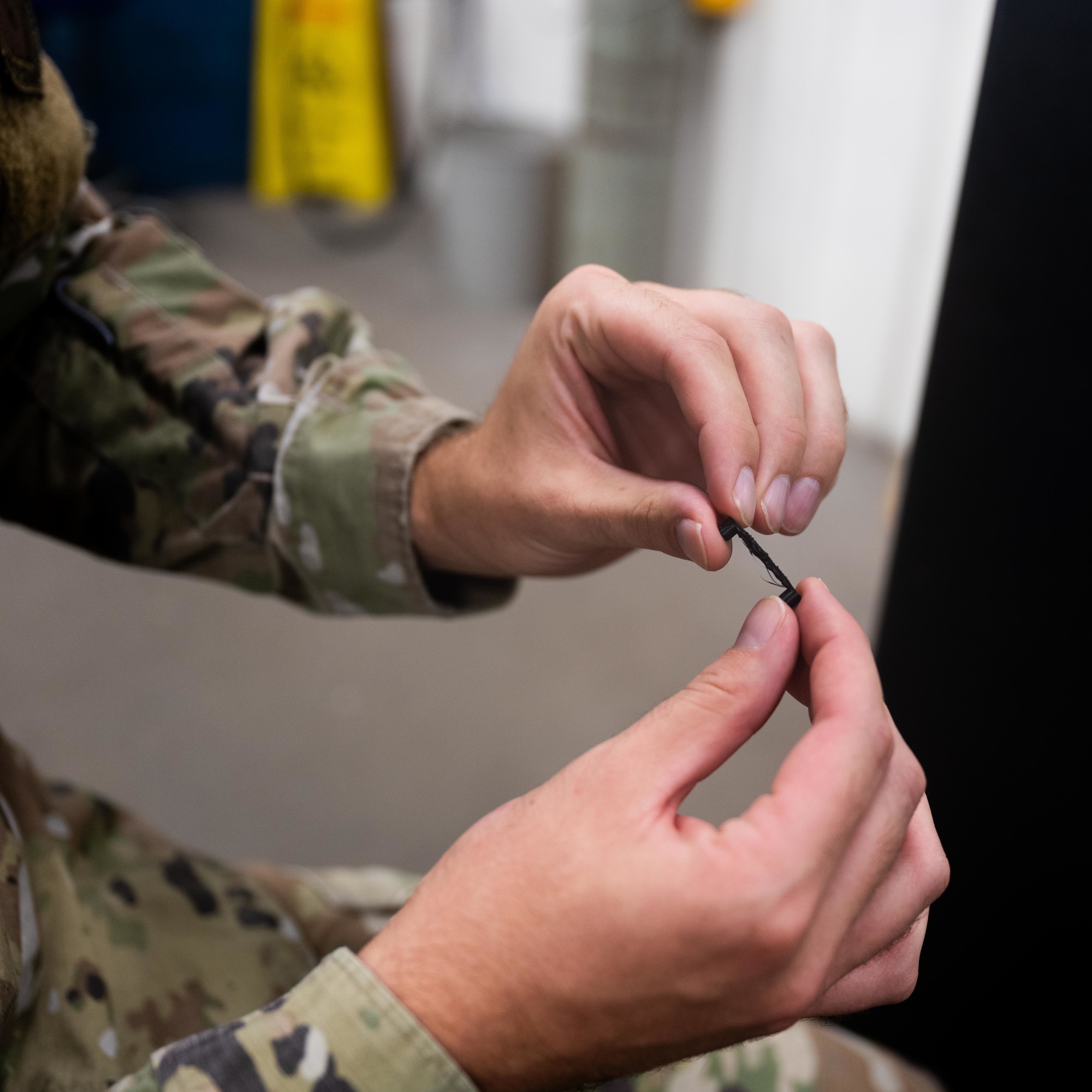 A maintainer with the 47th Flying Training Wing inspects a 3D-printed aircraft component at Laughlin Air Force Base, Texas Sept. 10, 2025. The Maintenance Directorate is using additive manufacturing to reproduce parts, reduce downtime and keep trainer aircraft mission ready. (U.S. Air Force photo by Airman 1st Class Harrison Sullivan)