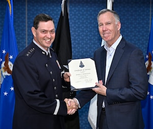 Gen Chance Saltzman presents a federal service award to Harry Mornston.