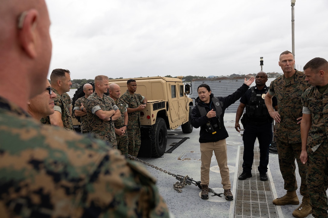 Krishelle Doronila, head of engineering, explains shoreline erosion to regional commanders and sergeants major aboard an Improved Navy Lighterage System Sept. 9, 2025, during the Marine Corps Installations East fall commander’s conference at Marine Corps Support Facility Blount Island in Jacksonville, Florida. The ferry is a key component of ship-to-shore movement during maritime prepositioning force operations. (U.S. Marine Corps photo by Dustin Senger)