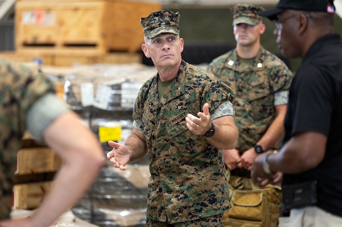 U.S. Marine Corps Brig. Gen. Ralph Rizzo Jr., commanding general of Marine Corps Installations East and Marine Corps Base Camp Lejeune, discusses materiel production with Thurman Bobbett, head of maintenance management at Blount Island Command, Sept. 9, 2025, during the Marine Corps Installations East fall commander’s conference at Marine Corps Support Facility Blount Island in Jacksonville, Florida. Bobbett oversees corrective and preventative maintenance procedures that keep prepositioned Marine Corps equipment combat-ready for global deployment. (U.S. Marine Corps photo by Dustin Senger)