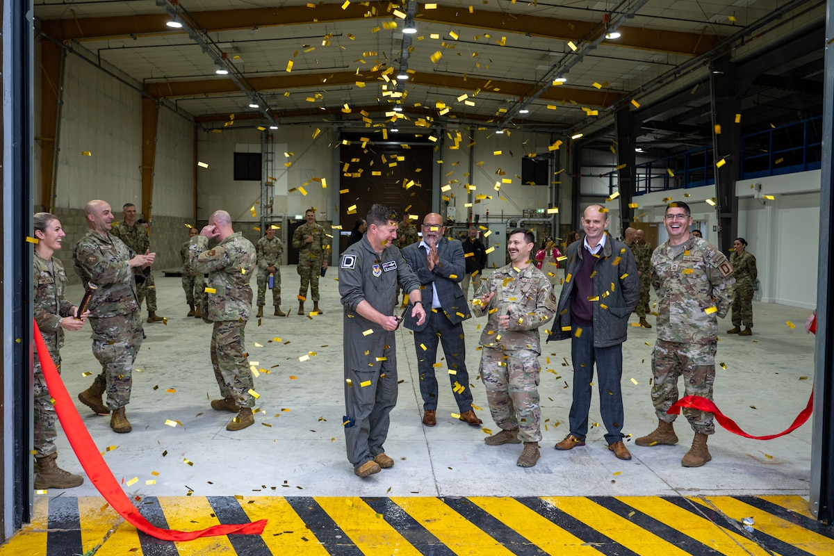 Airmen assigned to the 100th Air Refueling Wing celebrate the opening of the cargo deployment facility ribbon cutting at RAF Mildenhall, England, Sept. 4, 2025.