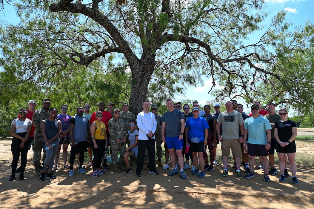 Members of the 960th Cyberspace Wing and 433rd Airlift Wing pose for a group photo Sept. 2, 2025, at Joint Base San Antonio-Lackland, Texas, after participating in a 5K run to kick off National Suicide Awareness and Prevention Month.