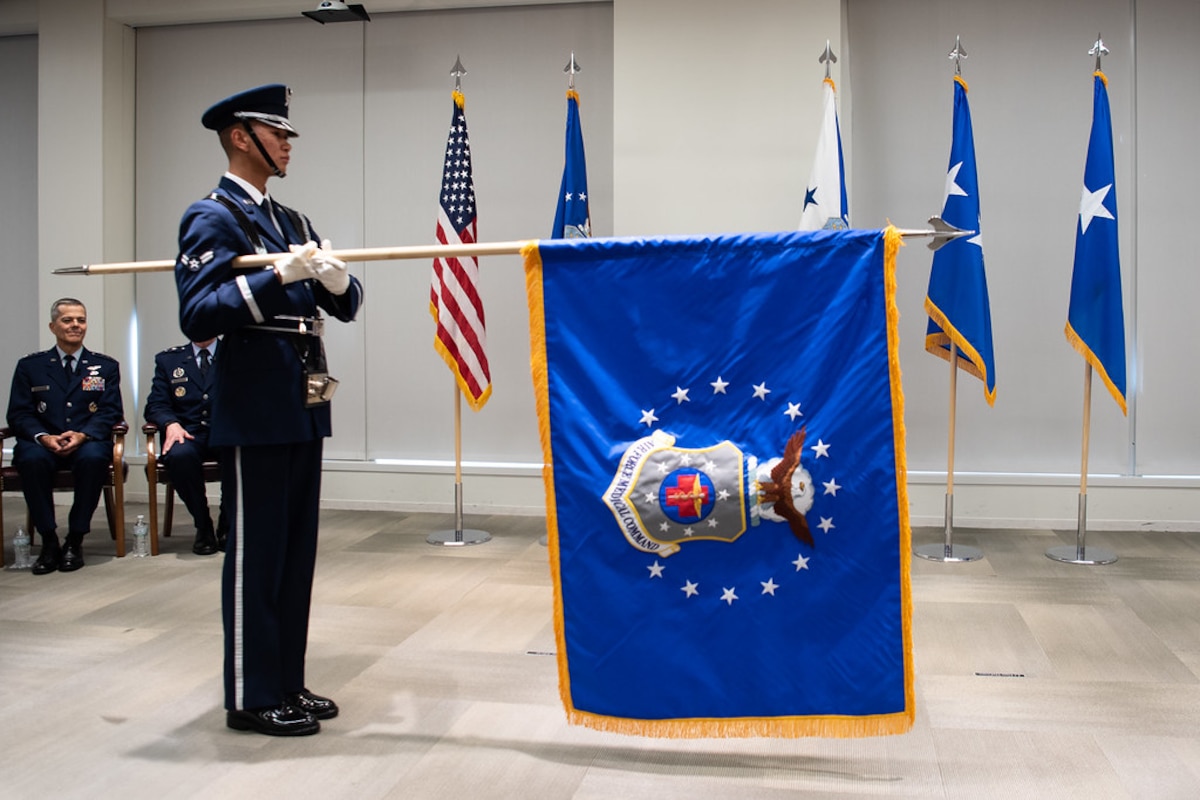 Image of an Airman unfurling a flag.