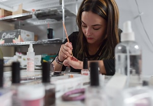 A woman applies moulage to her hand