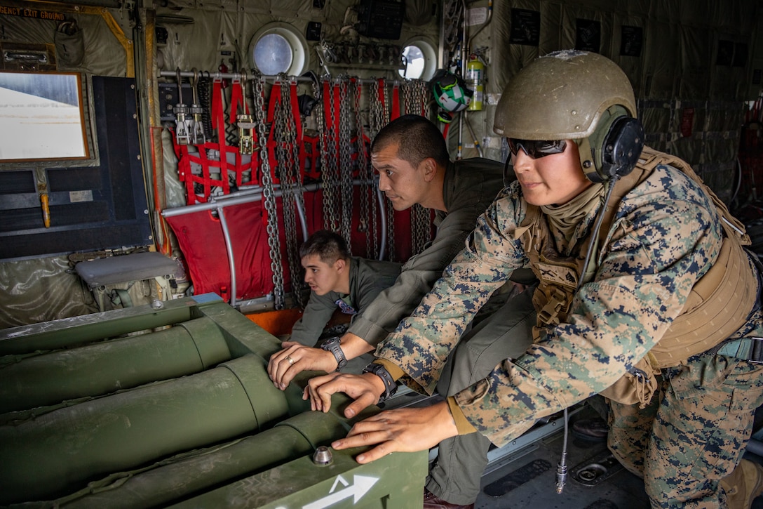 U.S. Marine Corps Cpl. Macro Morales, left, and Gunnery Sgt. Johnathon Lin, center, loadmasters with Marine Aerial Refueler Squadron 234 (VMGR-234), 4th Marine Aircraft Wing, and Sgt. Julio Torres, High Mobility Artillery Rocket System (HIMARS)  launcher chief, with 2nd Battalion, 14th Marine regiment, 4th Marine Division load new rocket casing during ARCTIC EDGE 2025 (AE25) at Fort Greenly, Alaska, Aug. 22, 2025. Specialized Arctic training generates valuable lessons learned for warfighters and enablers ensuring they can execute their assigned missions in any environment. AE25 is a NORAD and U.S. Northern Command-led homeland defense exercise designed to improve readiness, demonstrate capabilities and enhance Joint and Allied Force interoperability in the Arctic. (U.S. Marine Corps Photo by Lance Cpl. Edward Spears.)