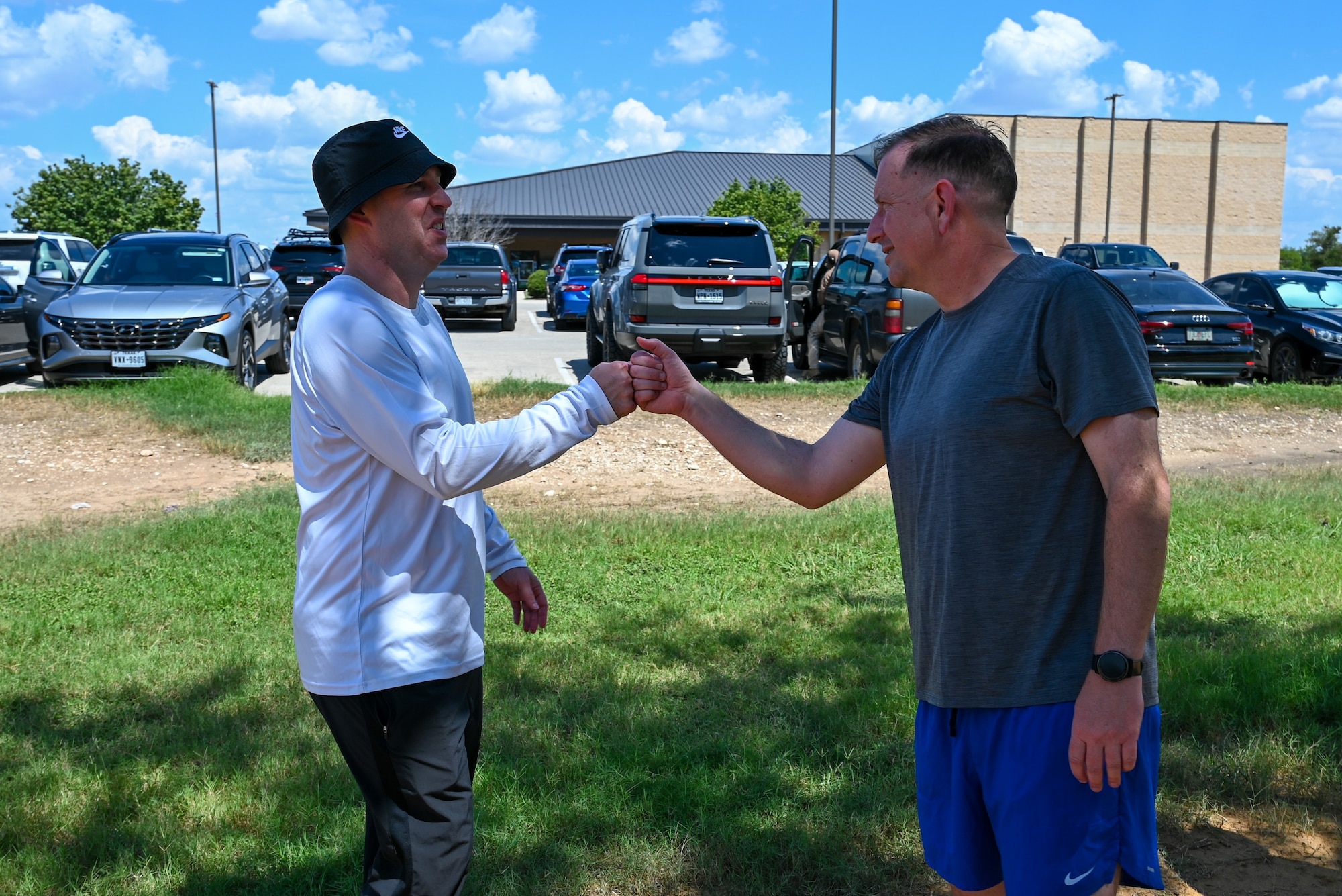 Col. Joshua Garrison, 960th Cyberspace Wing commander, bumps fists with Col. Douglas C. Jeffrey, 433rd Airlift Wing commander, before a 5K run at the Medina Chapman Fitness Center on Joint Base San Antonio-Lackland, Texas Sep. 2, 2025.