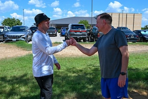 Col. Joshua Garrison, 960th Cyberspace Wing commander, bumps fists with Col. Douglas C. Jeffrey, 433rd Airlift Wing commander, before a 5K run at the Medina Chapman Fitness Center on Joint Base San Antonio-Lackland, Texas Sep. 2, 2025.
