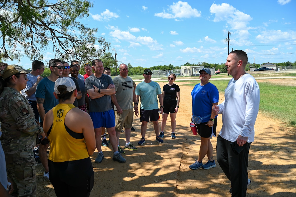 Col. Joshua Garrison, right, 960th Cyberspace Wing commander, addresses Airmen before a 5K run at the Medina Chapman Fitness Center on Joint Base San Antonio-Lackland, Texas Sep. 2, 2025.