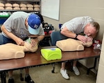 Harney Sports Complex staff John Boyer and Matt Price use CPR masks from a first aid kit to administer rescue breathing during Cardiopulmonary Resuscitation (CPR) training at Munson Army Health Center, Fort Leavenworth, Kansas, Aug. 29. CPR masks improve the effectiveness of rescue breaths by providing a proper seal, ensuring a clear air way, and protects the rescuer from germs, viruses, and blood-borne pathogens from the victim.