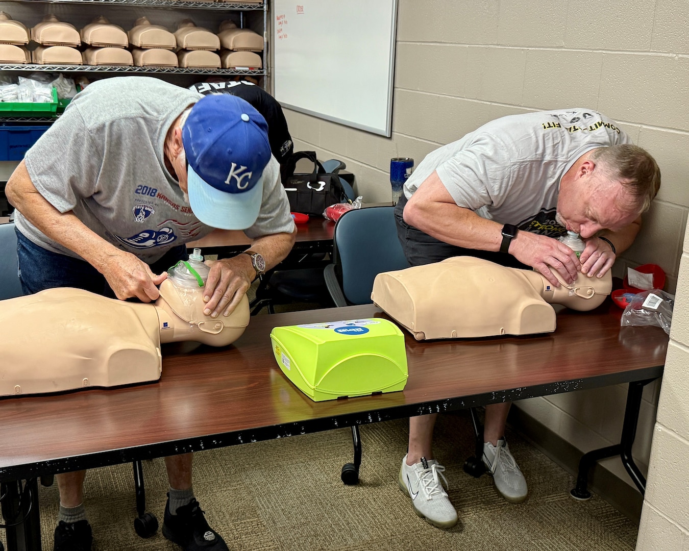 Harney Sports Complex staff John Boyer and Matt Price use CPR masks from a first aid kit to administer rescue breathing during Cardiopulmonary Resuscitation (CPR) training at Munson Army Health Center, Fort Leavenworth, Kansas, Aug. 29. CPR masks improve the effectiveness of rescue breaths by providing a proper seal, ensuring a clear air way, and protects the rescuer from germs, viruses, and blood-borne pathogens from the victim.