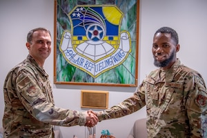 Col. Michael S. Albert, 434th Air Refueling Wing commander, Grissom Air Reserve Base, Indiana, coins Tech. Sgt. Abdoulie Bah, Team Grissom recruiter, 350th Recruiting Squadron, for breaking a recruiting record by reaching 100 accessions within the 2025 fiscal year, becoming a ’Centurian Club’ recruiter August 9, 2025. The last time a recruiter accessed 100 or more new Airmen was in 2014 and there have been fewer than 10 to earn the distinction within the past 20 years. (U.S. Air Force photo by Master Sgt. Benjamin Mota)