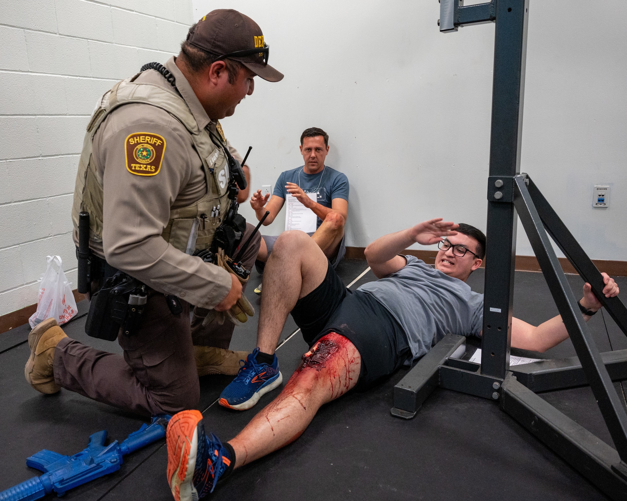 A Val Verde Sheriff officer checks a wounded hostage during an exercise at Laughlin Air Force Base, Texas, Sept. 4, 2025. Officers breached the room and neutralized the threat, allowing them to check on the hostages and give first aid. (U.S. Air Force photo by Staff Sgt. Nicholas Larsen)