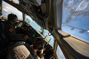 Airmen pilot a C-17 while a KC-46 prepares to refuel
