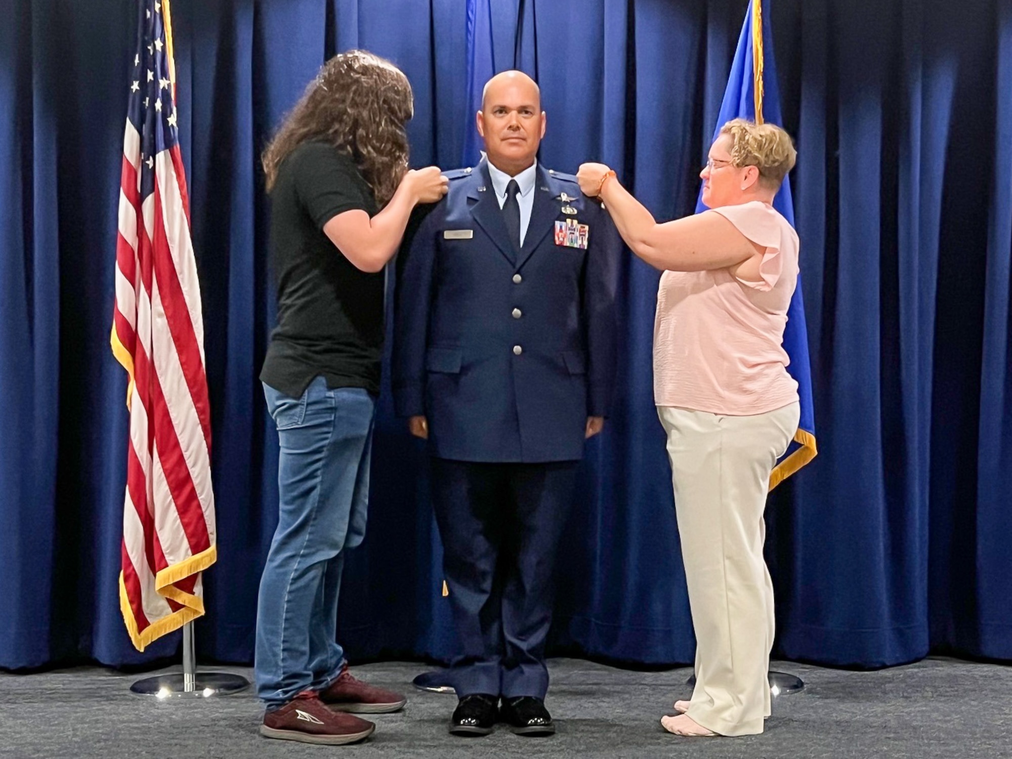 CWO2 Dell stands at attention while his family members pin on his new warrant officer 2 rank.