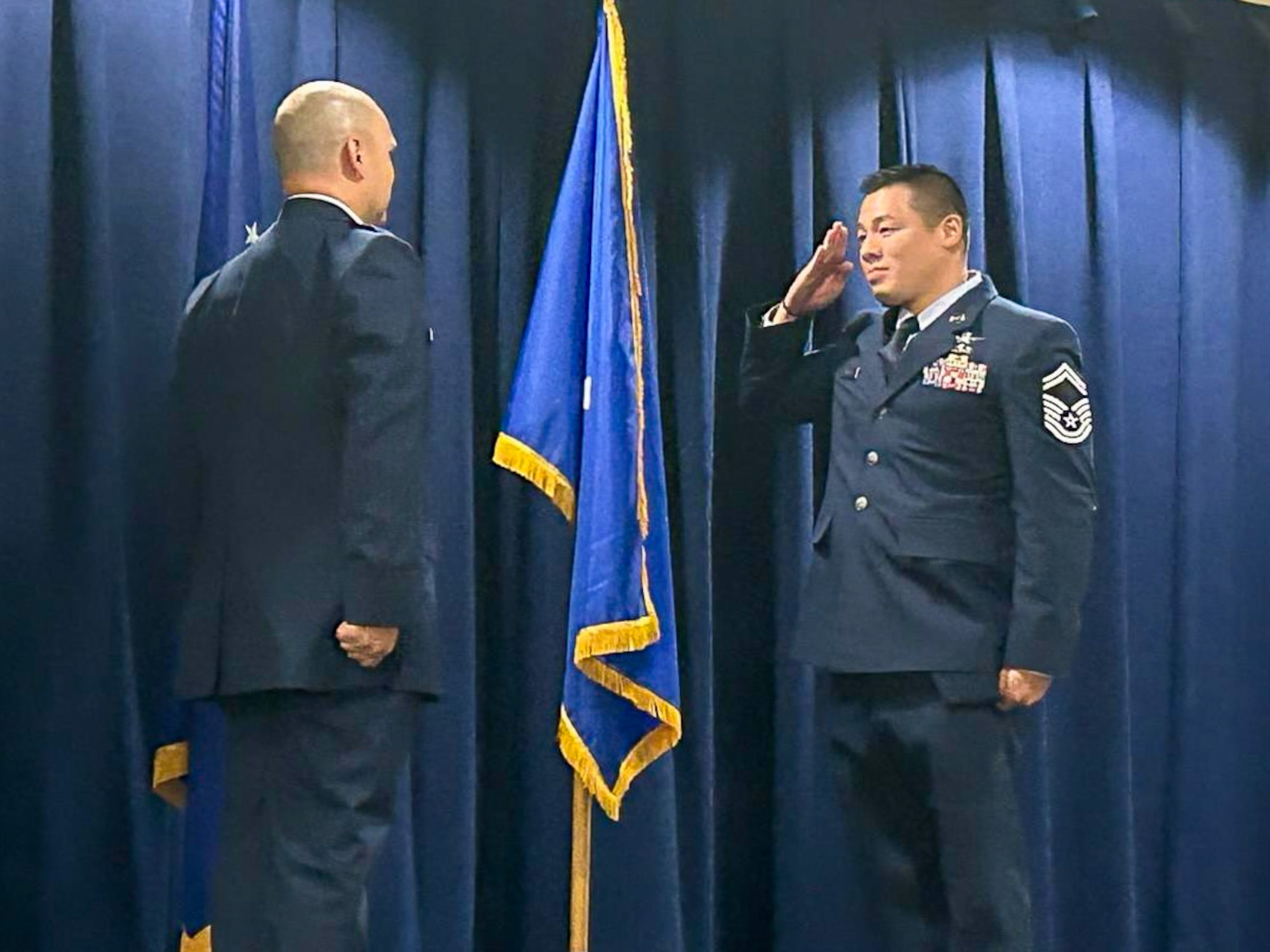 CWO2 stands at attention while a SMSgt renders his first salute.