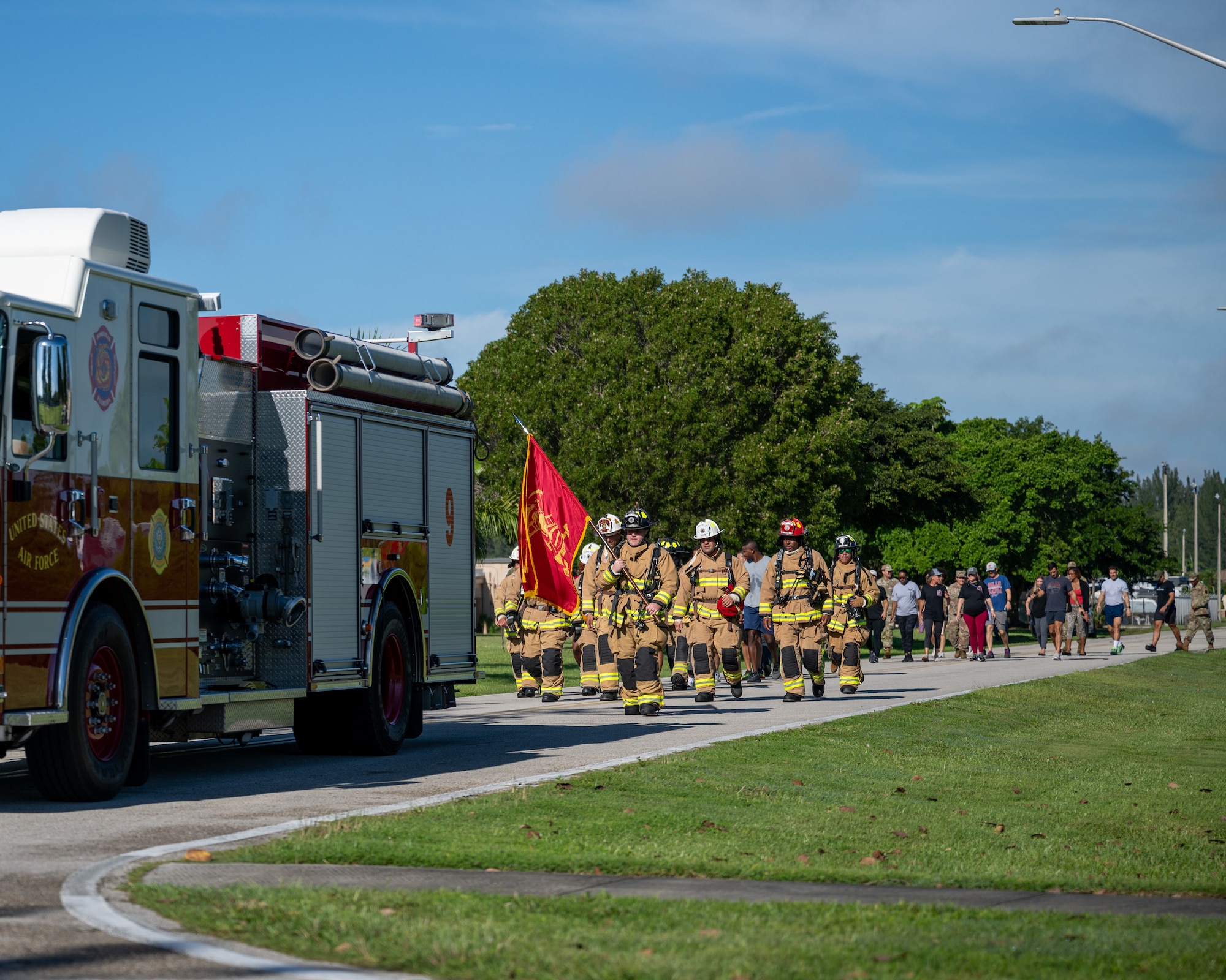 Firefighters and community members take part in a one-mile memorial walk in tribute to the fallen of Sept. 11, 2001, at Homestead Air Reserve Base, Florida, Sept. 11, 2025. All participants joined the walk, with firefighters completing the march in full gear. (U.S. Air Force photo by Master Sgt. Lionel Castellano)