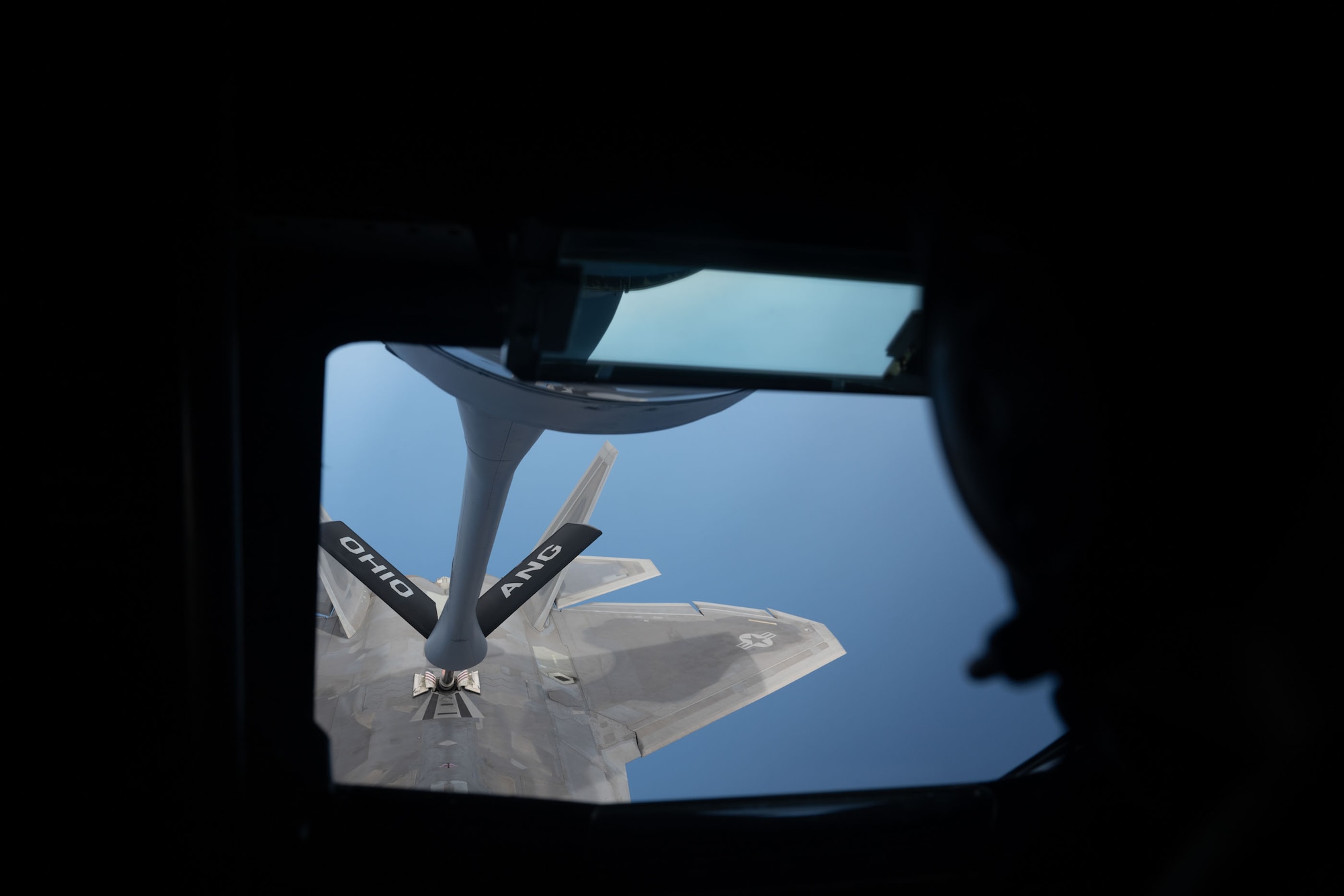 View through KC-135 boom pod window of F-22 Raptor being refueled