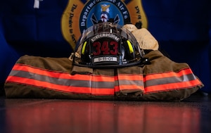 A tribute composed of fire-fighting gear is displayed during a 9/11 memorial ceremony
