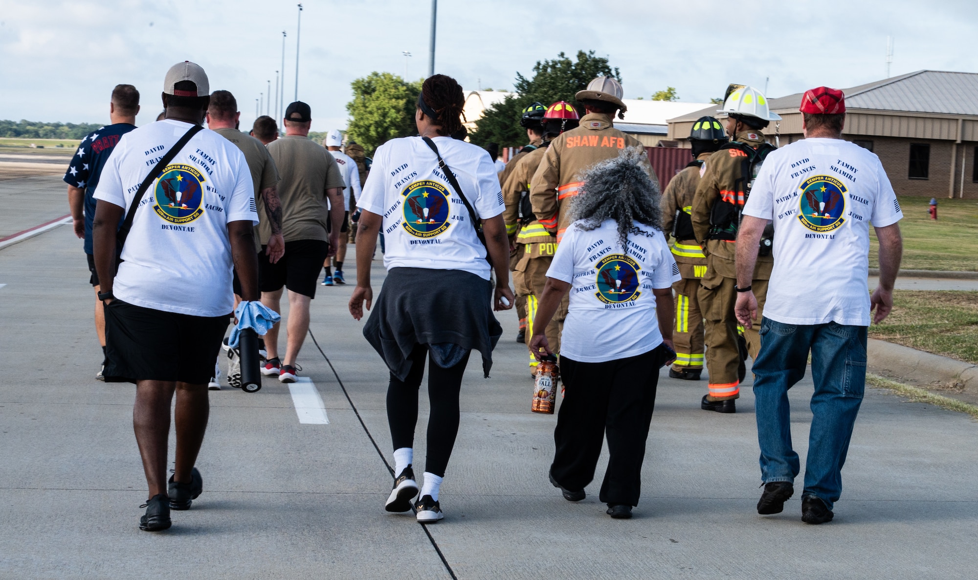 People with matching 9/11 memorial shirts walk in a line during a 5k.