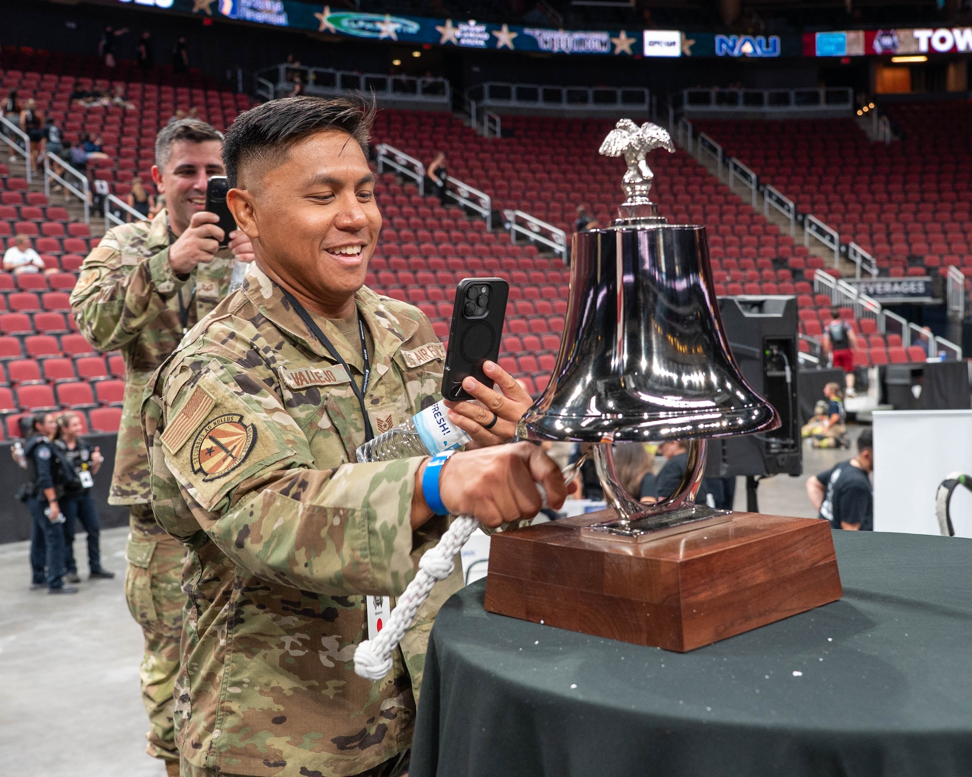 U.S. Air Force Tech. Sgt Gabriel Vallejo, 362nd Recruiting Squadron alighted accessions recruiter, and Tech. Sgt Christopher Peluso, 362nd Recruiting Squadron alighted accessions recruiter, ring a bell upon completion of the 2025 Tower Challenge at Desert Diamond Arena, Glendale, Arizona, Sept. 6, 2025.