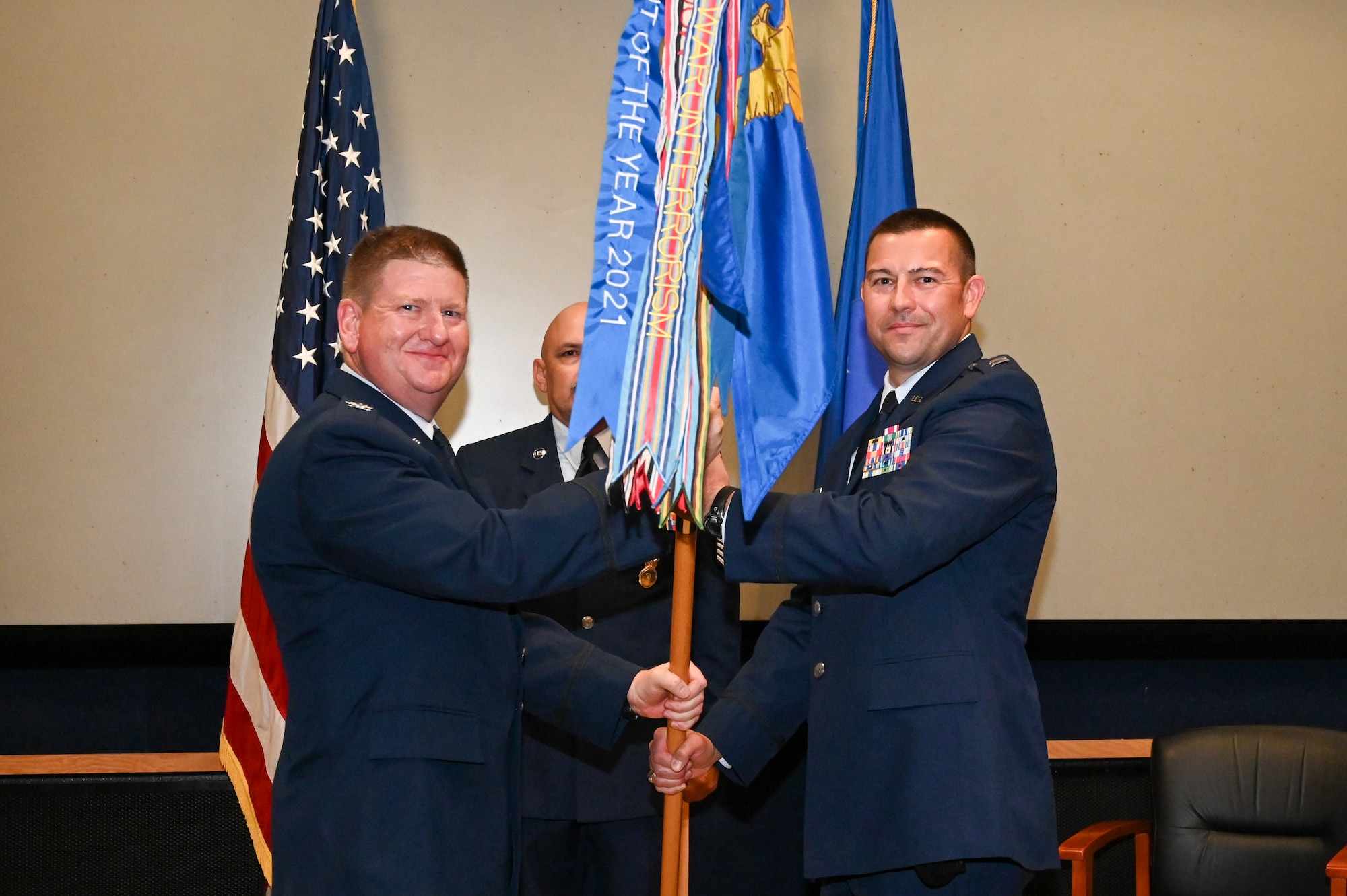 Col. Jeremy Patrick, 433rd Mission Support Group commander, presents the 433rd Security Forces Squadron guidon to Capt. Scott Bean, 433rd SFS commander, during an assumption of command ceremony at Joint Base San Antonio-Lackland, Texas, Sept. 6, 2025.