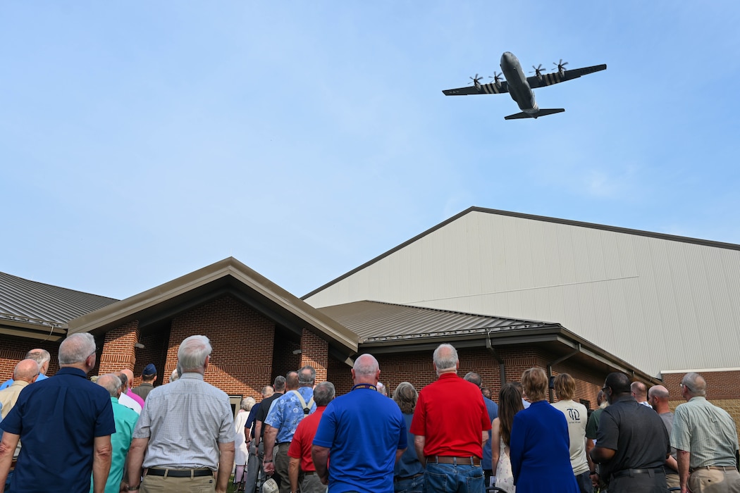 An aircraft flies over a ceremony.